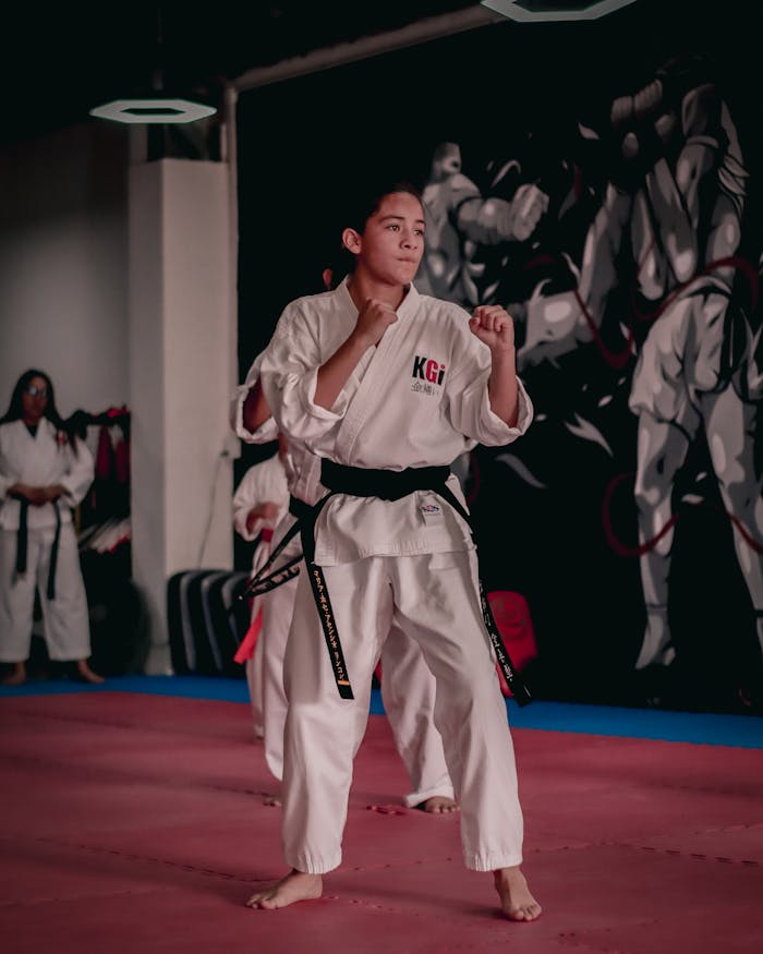 Karate practitioner in white gi training in an indoor gym setting.