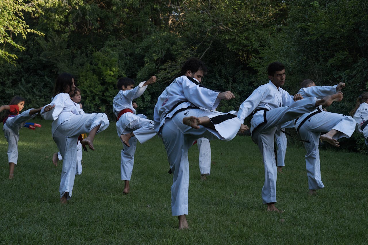Group of karate students practicing high kicks outdoors in Buenos Aires.